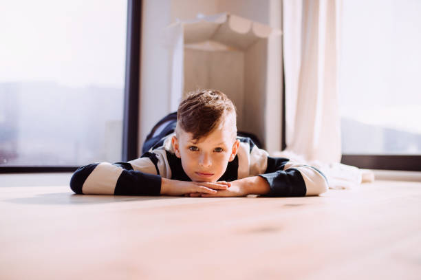 istock A small boy lying indoors on the floor at home. Copy space. 1147133636