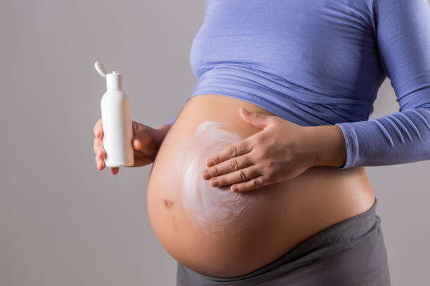 soins de la peau pendant la grossesse - human pregnancy abdomen human skin healthcare and medicine photos et images de collection