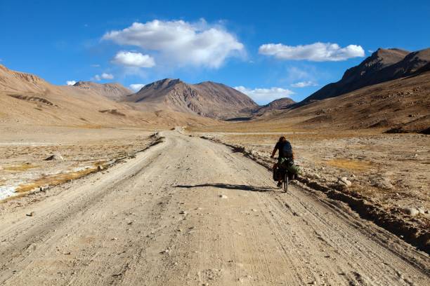 pamir highway ou pamirskij trakt avec biker, tadjikistan - pamirs photos et images de collection