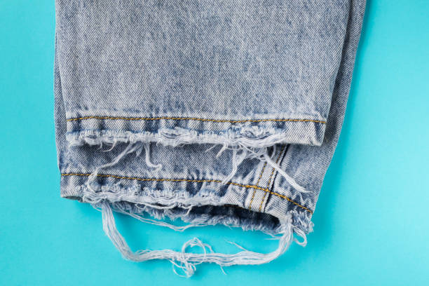istock Old used jeans on a blue background close-up. 1147139729