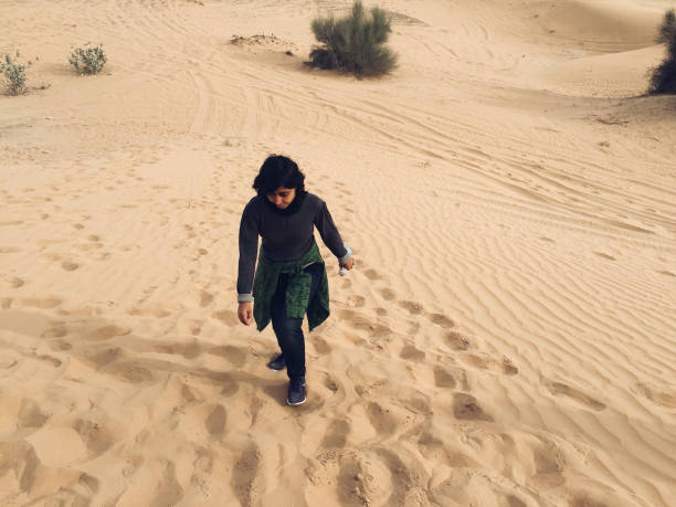 istock Young woman hiking through sand dune 1147140572
