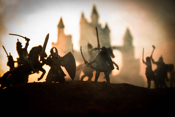 istock Medieval battle scene with cavalry and infantry. Silhouettes of figures as separate objects, fight between warriors on sunset foggy background. 1147142229