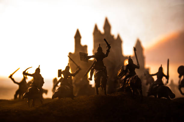 istock Medieval battle scene with cavalry and infantry. Silhouettes of figures as separate objects, fight between warriors on sunset foggy background. 1147142231