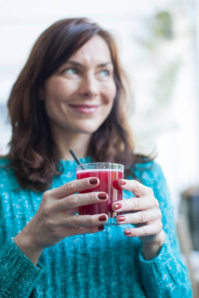 istock woman drinking juice 1147156181