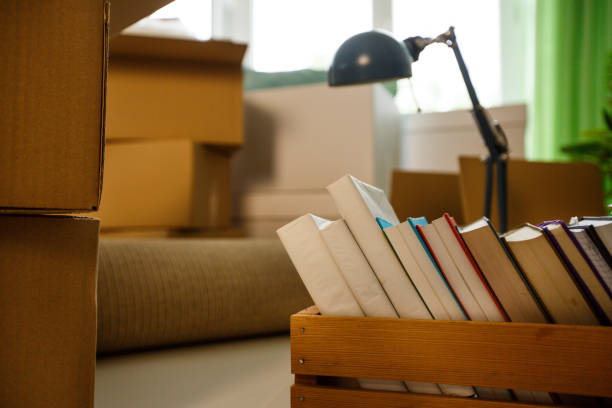 istock Books in wooden crate and moving boxes 1147161404