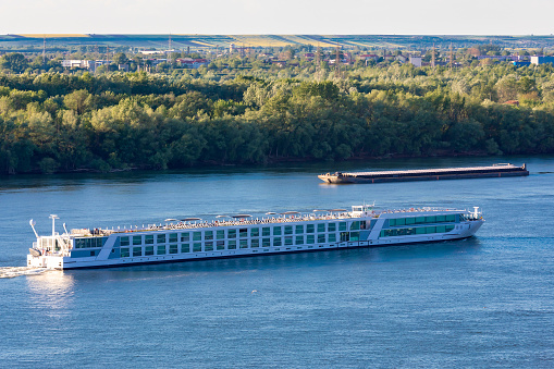 Passenger ship in Danube river at Ruse Port at Bulgaria and Barge sailing Romanian side.