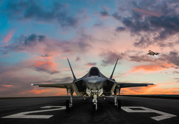F-35 fighter jet ready to takeoff on runway at sunset stock photo