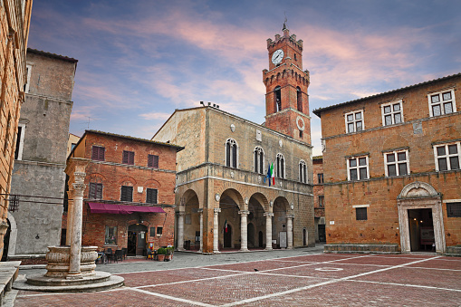 Pienza, Siena, Tuscany, Italy: the main square with the ancient city hall and the beautiful water well of the picturesque medieval town
