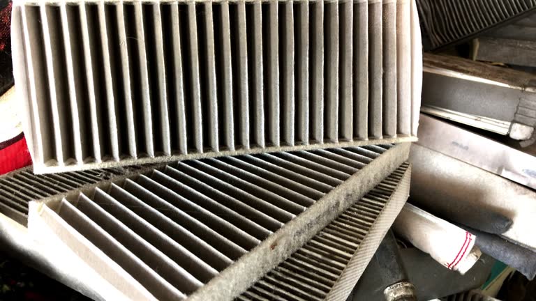 MS Hand-held Camera and selective focus with film color grading. Use for background clip or insert shot of Dirty used car engine air filters in auto repair shop.