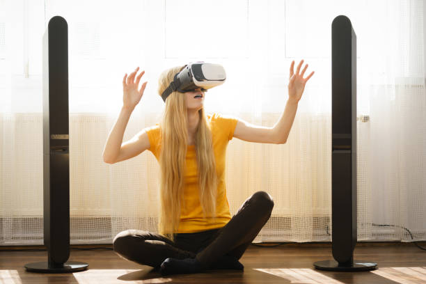 istock Girl wearing virtual reality goggles at home 1147178107