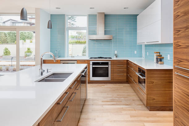 섬, 펜 던 트 조명, 나무 바닥 및 스테인레스 스틸 가전 제품과 함께 새로운 현대적인 스타일의 고급 주택에 아름 다운 현대 부엌. 천장에 확장 블루 톤 타일을 갖추고 있습니다 - 모던 양식 뉴스 사진 이미지