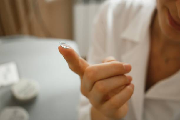 istock Female finger with contact lens on blurred background 1147182079