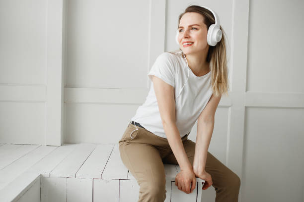 음악을 즐길 수 있습니다. 행복 한 젊은 여자 흰색 헤드폰에서 즐거운 음악. - blowing hair audio 뉴스 사진 이미지