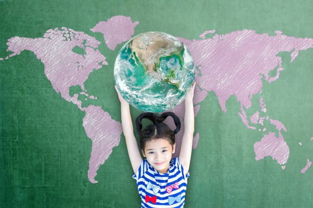 happy asian girl child student raising globe on school chalkboard for world literacy and gender equality concept. elements of this image furnished by nasa - earth globe mother child imagens e fotografias de stock