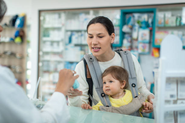 mother with a child testing hand cream - sales clerk imagens e fotografias de stock
