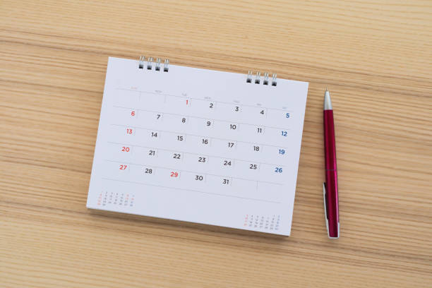 istock calendar page with pen on wood table background 1147196597