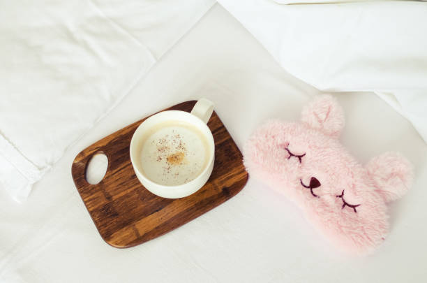 istock Cup of coffee with cute pink sleep mask 1147196679