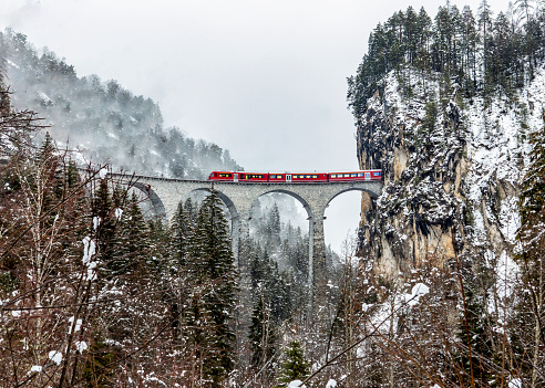 Photo from valley below Landwasser Viaduct of train crossing the stone bridge