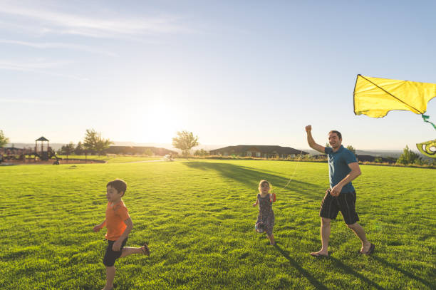 istock Dad flying kites with his kids at the park 1147200883