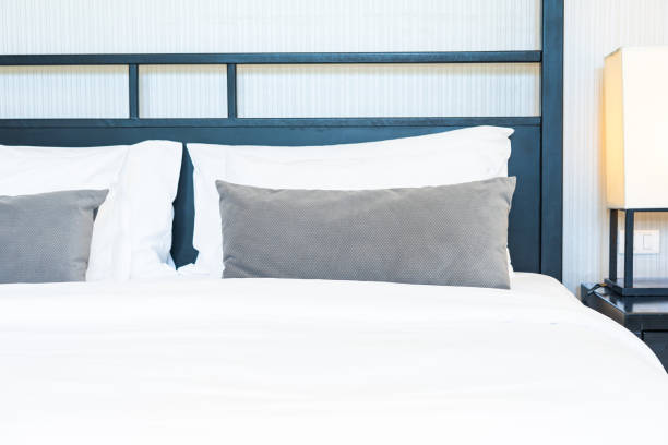 istock Beautiful luxury comfortable pillow on bed with light lamp 1147201239