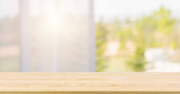 istock Empty wood table top with window curtain abstract blur background for product display 1147204795
