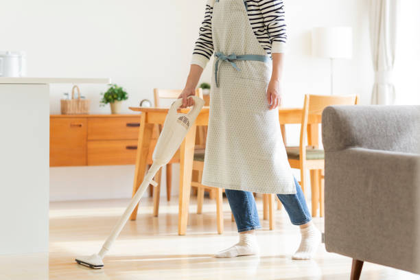 Housewife cleaning with vacuum cleaner stock photo