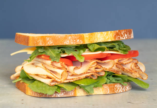 istock reshly made deli style sandwich with lettuce, several different kinds of vegetables, tomatoes, cheese, meats similar to ham, chicken or turkey. Great for printed menus, online food ordering, food marketing campaigns or posters. 1147219924