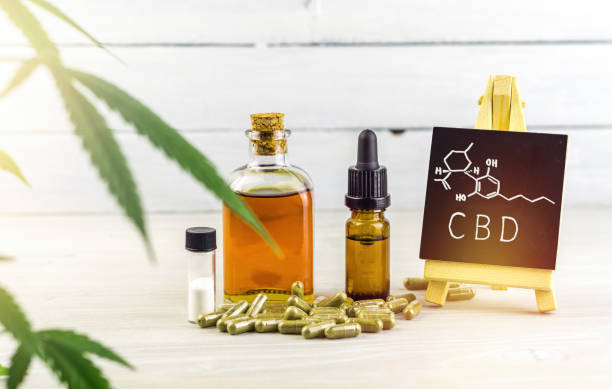Cannabidiol CBD oils, capsules and crystals isolate with small blackboard with CBD word and chemical structure Cannabidiol CBD oils, capsules and crystals isolate with small blackboard with CBD word and chemical structure on wooden backdrop cbd oil photos stock pictures, royalty-free photos & images