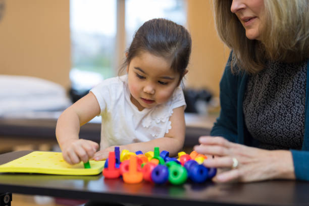 istock Occupational therapist works with a young ethnic girl 1147221608