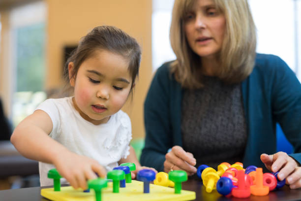 istock Occupational therapist works with a young ethnic girl 1147221610