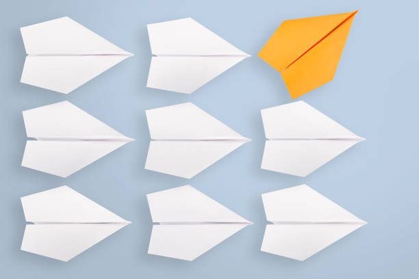 istock Change concepts with orange paper airplane leading among white 1147222716