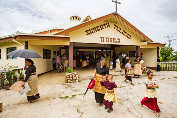 Polynesian parishioners in traditional Tongan dress walk out of church Sangata Teleisia 'o 'Avila as Catholic Mass ends, Pangai village, Ha'apai Group in Tonga, Polynesia stock photo