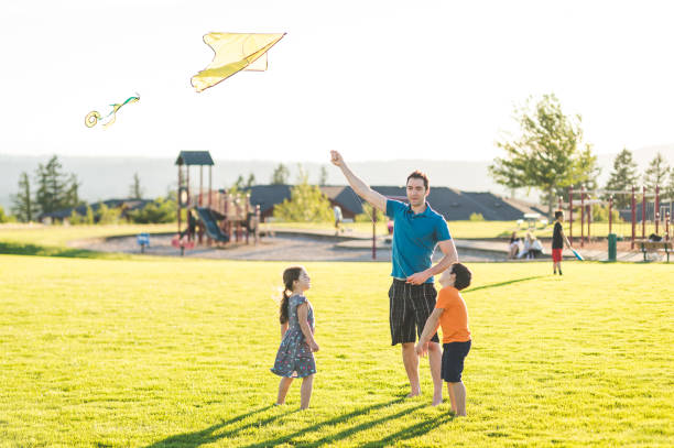 istock Dad flying kites with his kids at the park 1147223932