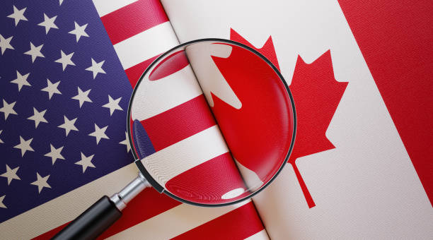 american and canadian flag pair under a magnifier - canada american flag canadian culture usa stock-fotos und bilder