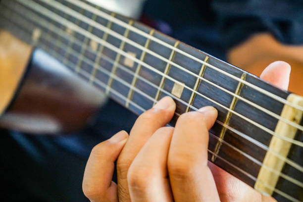 istock close up hand playing guitar 1147233523
