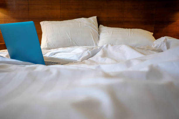 istock Laptop on white bed. Work at home concept 1147239822