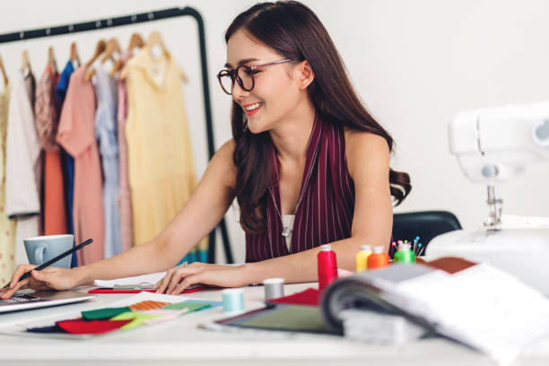 istock Smiling asia woman fashion designer working with laptop computer at workshop studio 1147239954