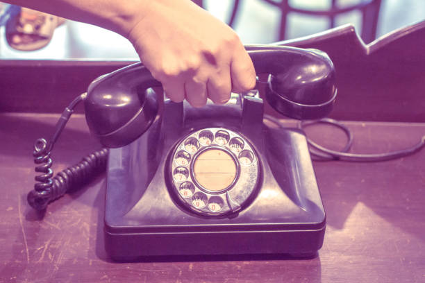 istock Telephone on wooden table and antique background 1147242372