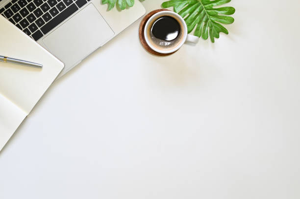 istock Office desk with laptop computer, notebook and coffee on table. 1147245156