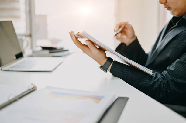istock Audit working, Businessman work with paper document on clipping board in office. 1147245350