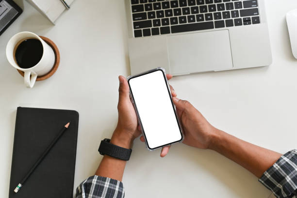 istock Cropped shot hands using mockup smartphone on office desk with clipping path. 1147245351