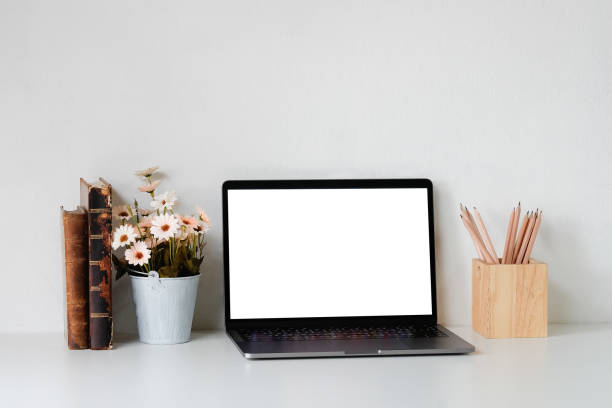 istock Mockup laptop computer, books, pencil and flower on table. 1147245449