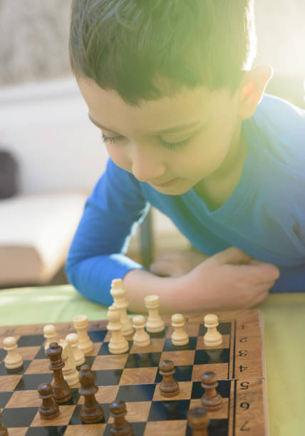 istock Clever child is concentrated and thinking while playing chess 1147245578