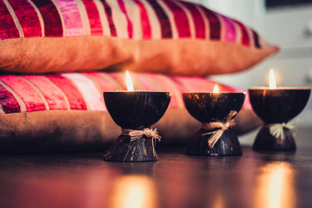istock Burning spa aroma candles in a coconut shell and  burgundy pillows with a pattern, cozy home interior background 1147247454