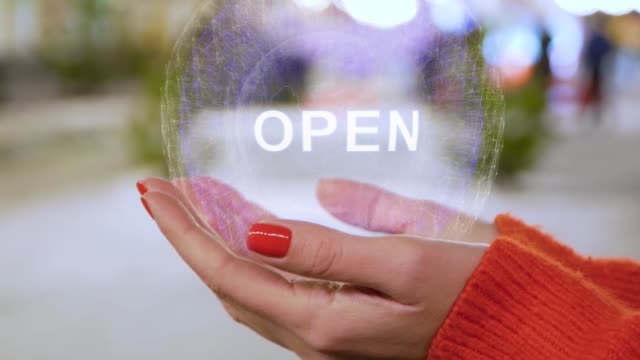 Female hands holding hologram with text Open