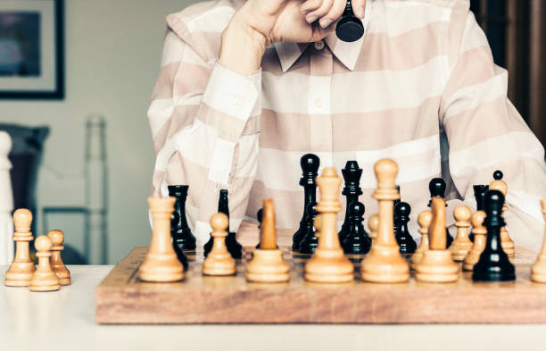 istock Wooden chess pieces on a chessboard, chess game woman player makes a move 1147247874