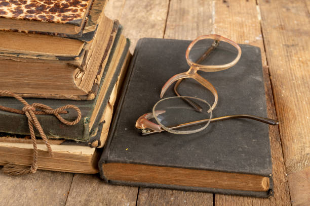 istock Broken frame from glasses. Old book and glasses. Dark background. 1147250089