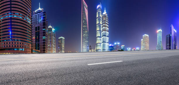 istock Shanghai modern commercial office buildings and empty asphalt highway at night 1147250119