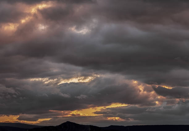 Springtime sunset with rain clouds and mountains in background.