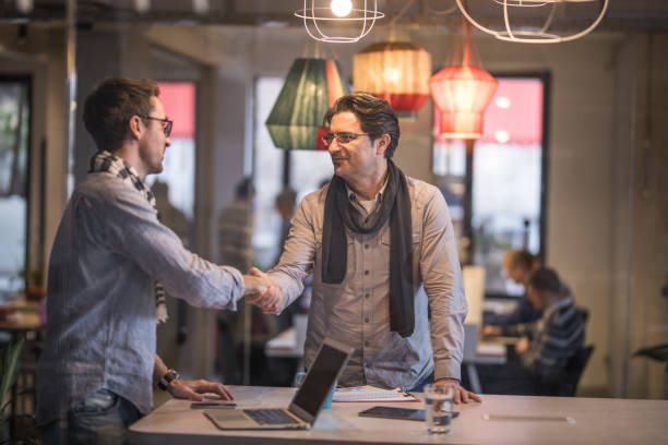 istock Two entrepreneurs shaking hands while meeting in the office. 1147254031